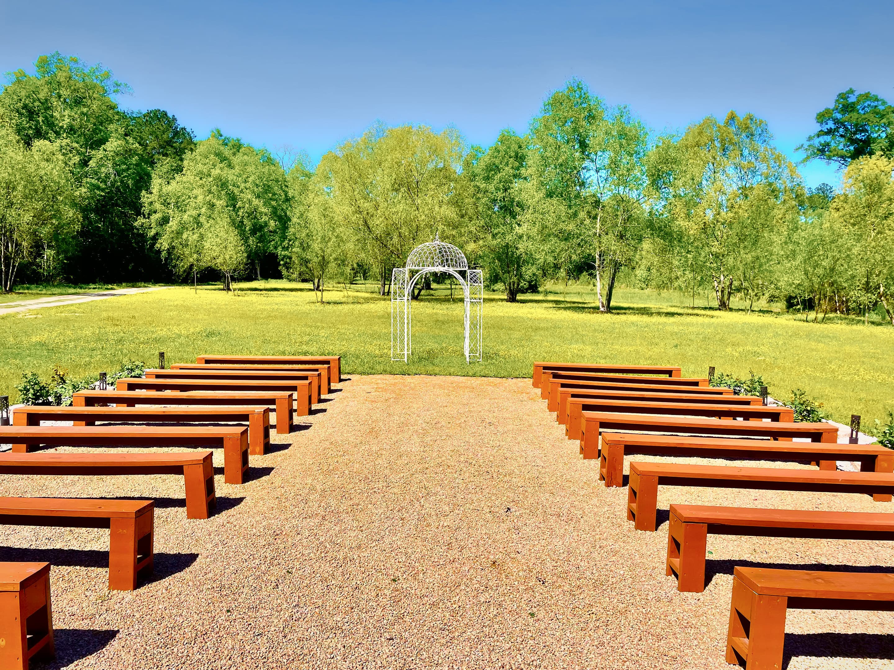Rows of timber benches either side of a gravel aisle leading to the white gazebo
