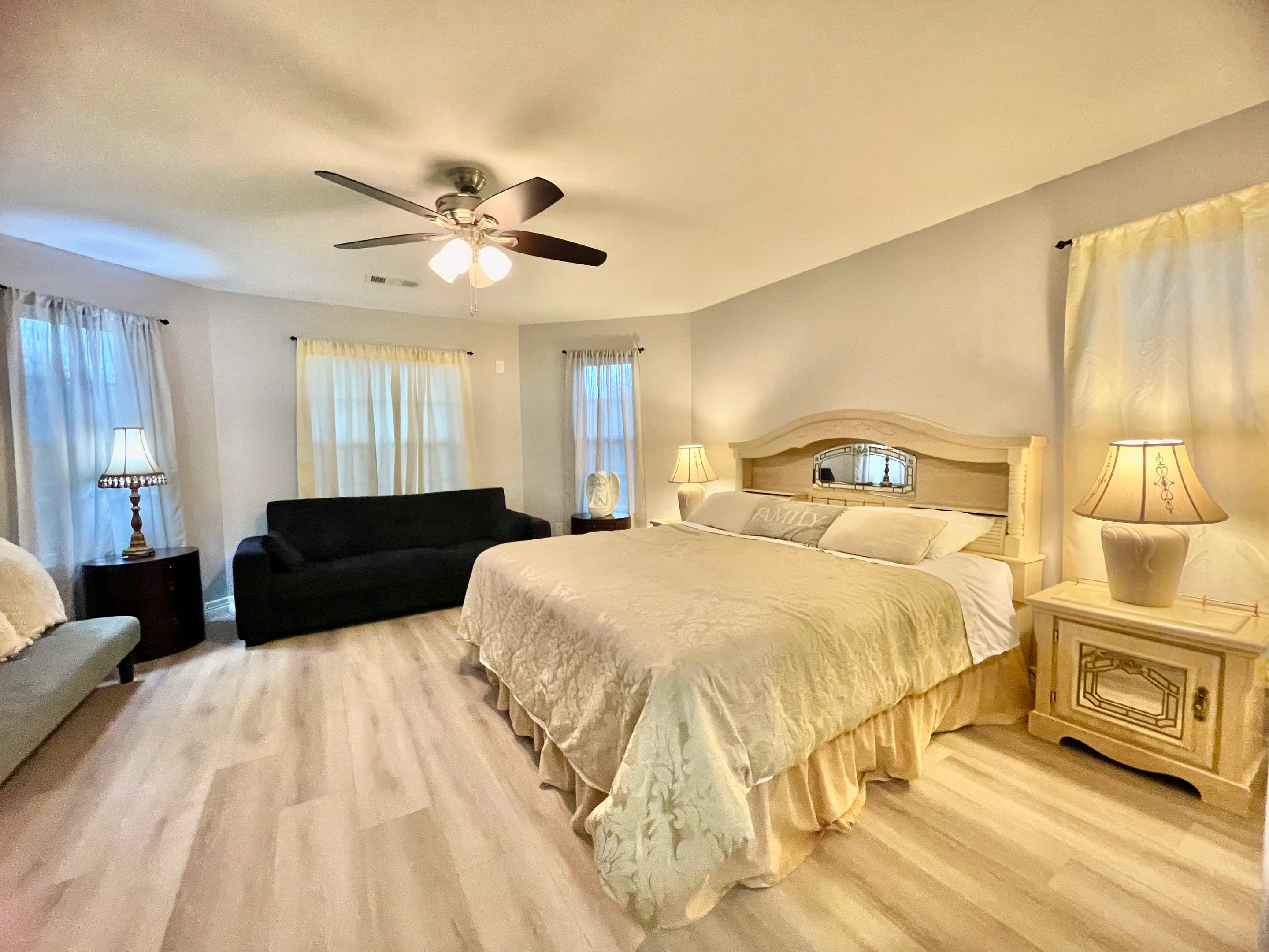 A guest room in soft neutrals with a king bed and bedside lamps