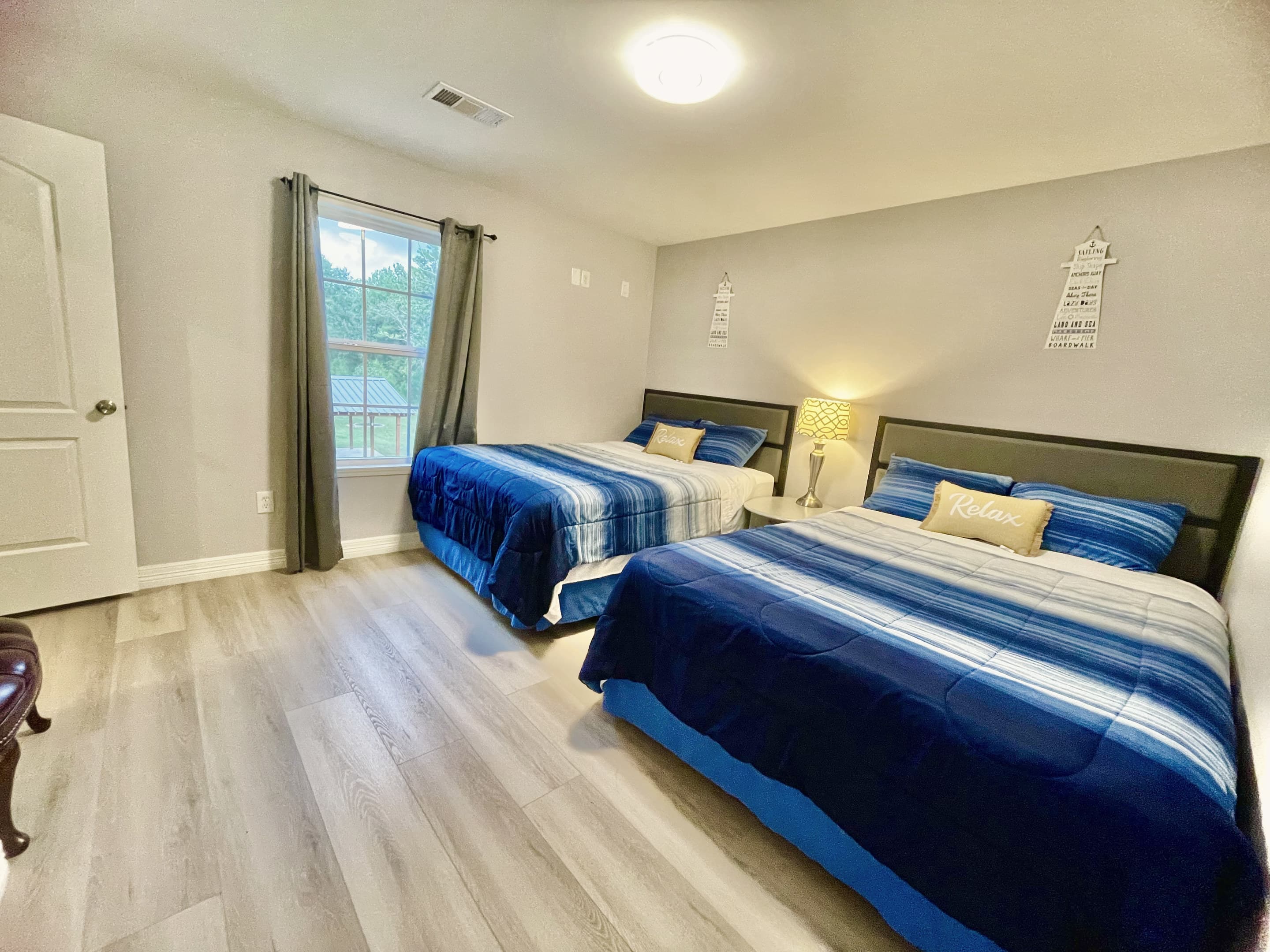A guest room with two beds dressed in navy and white