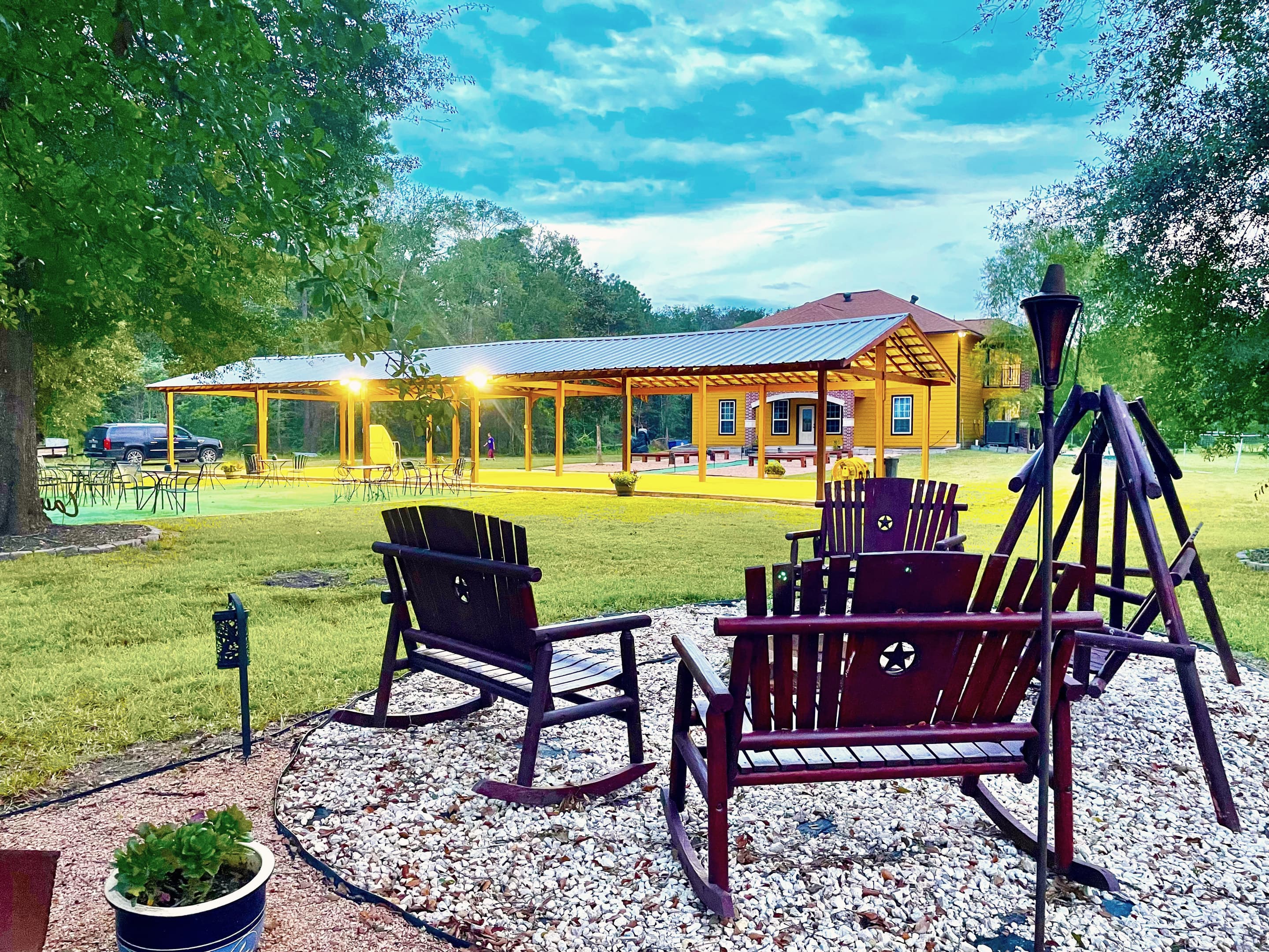 Adirondack chairs and a porch swing by the fire pit, the pavilion beyond