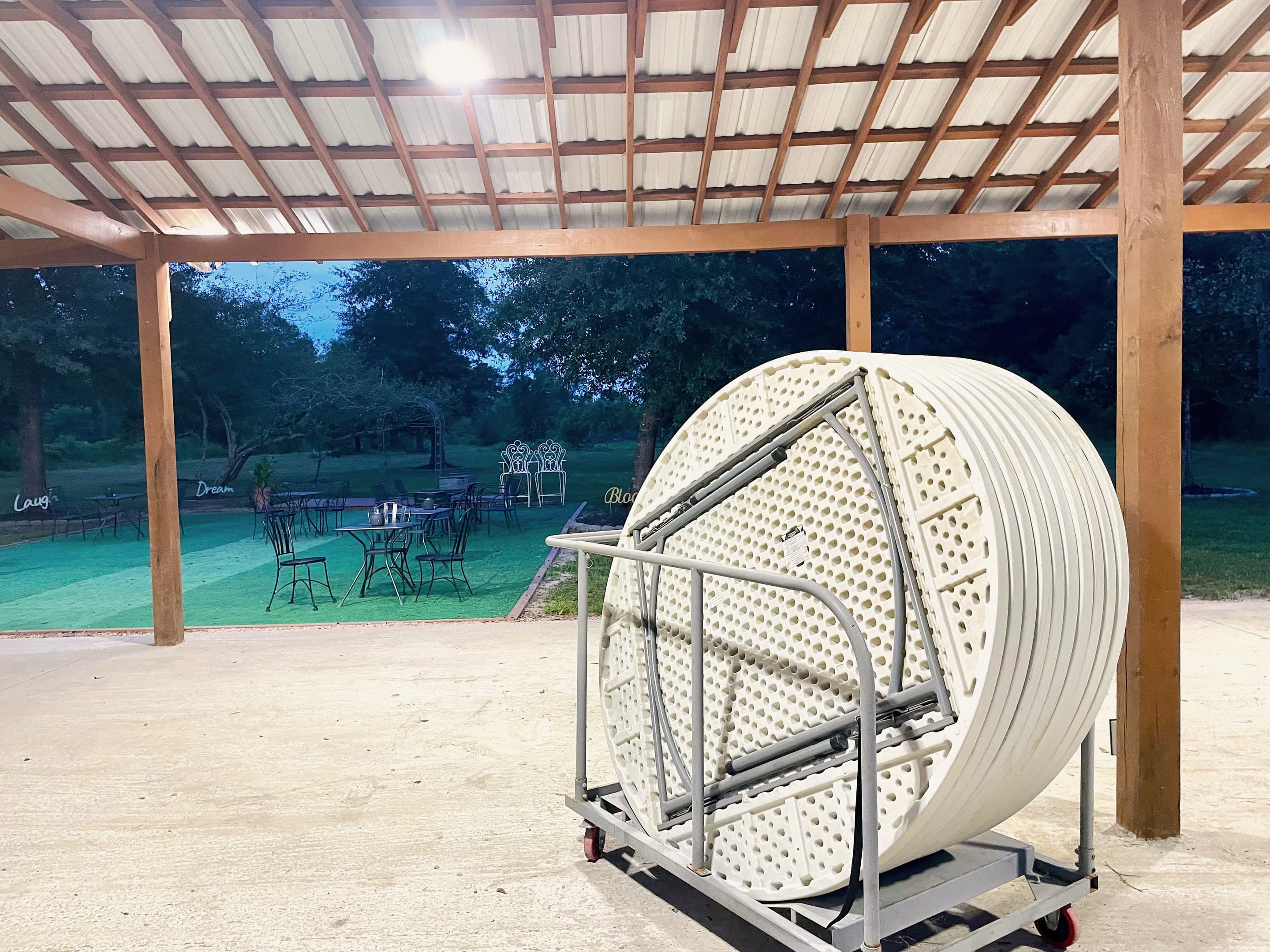 Round party tables on a rolling cart under the pavilion