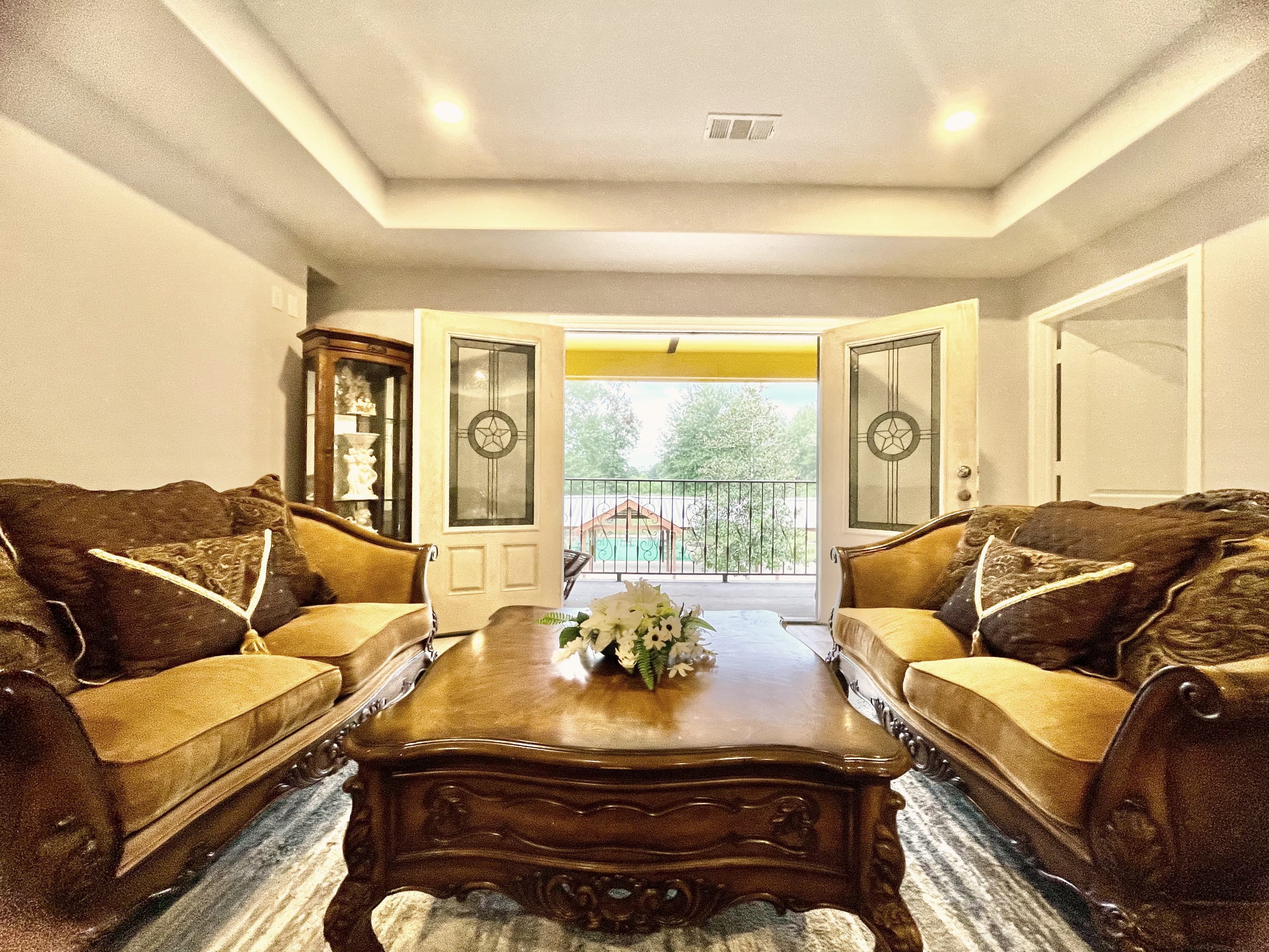 The formal living room with carved sofas around a coffee table