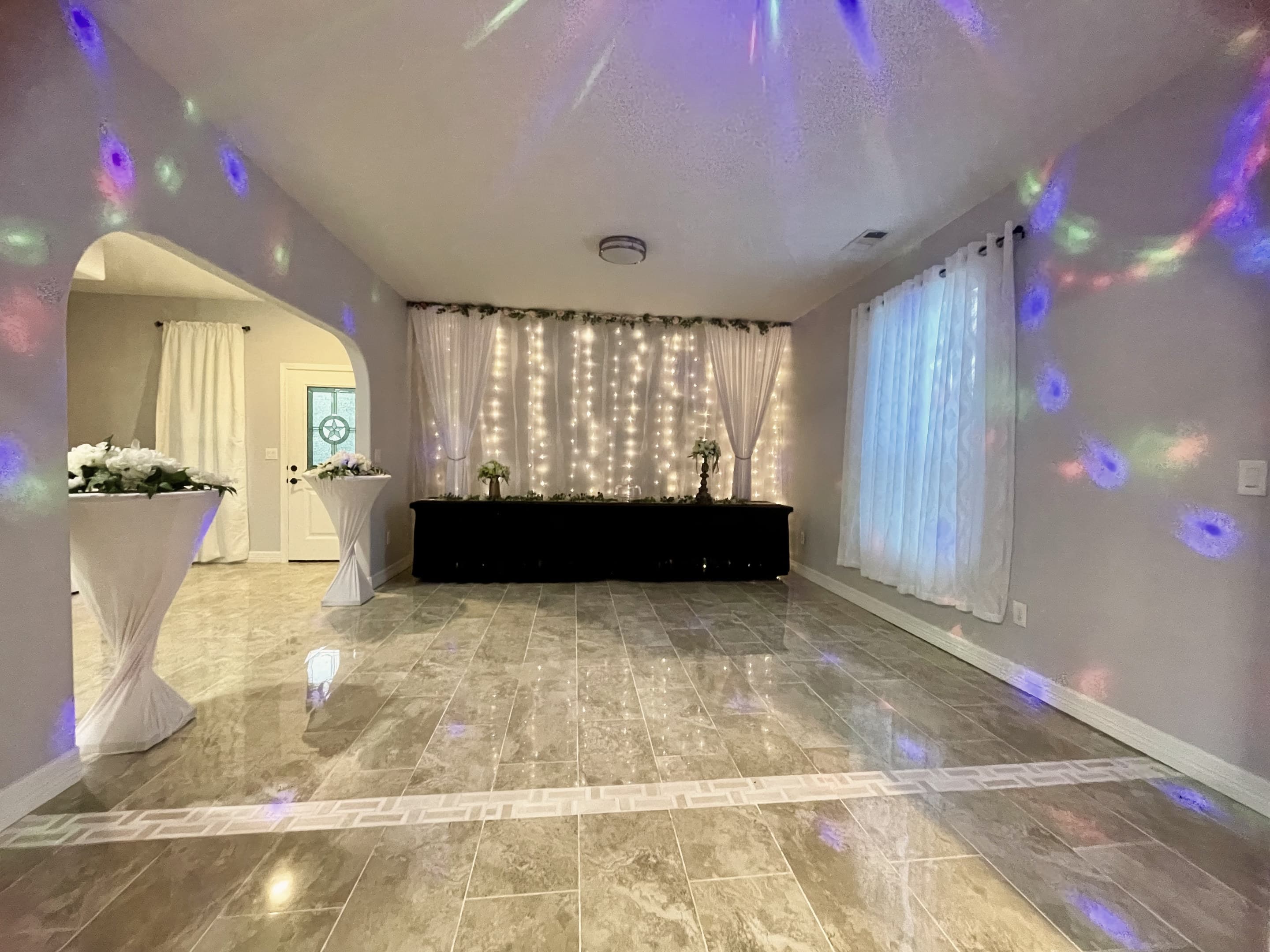 The party room lit with coloured lights and a fairy-light backdrop