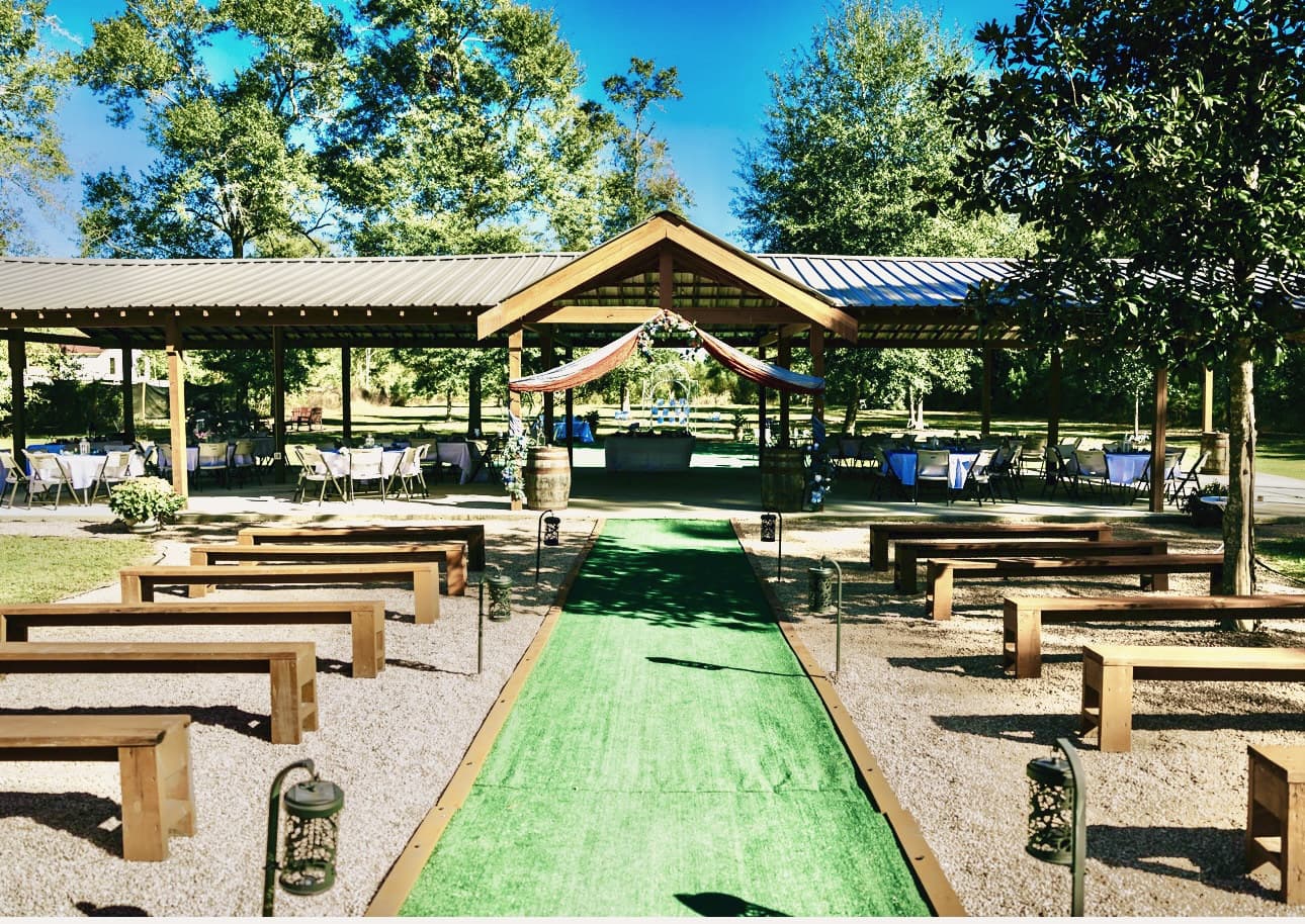Timber benches either side of a turf aisle leading to the covered pavilion