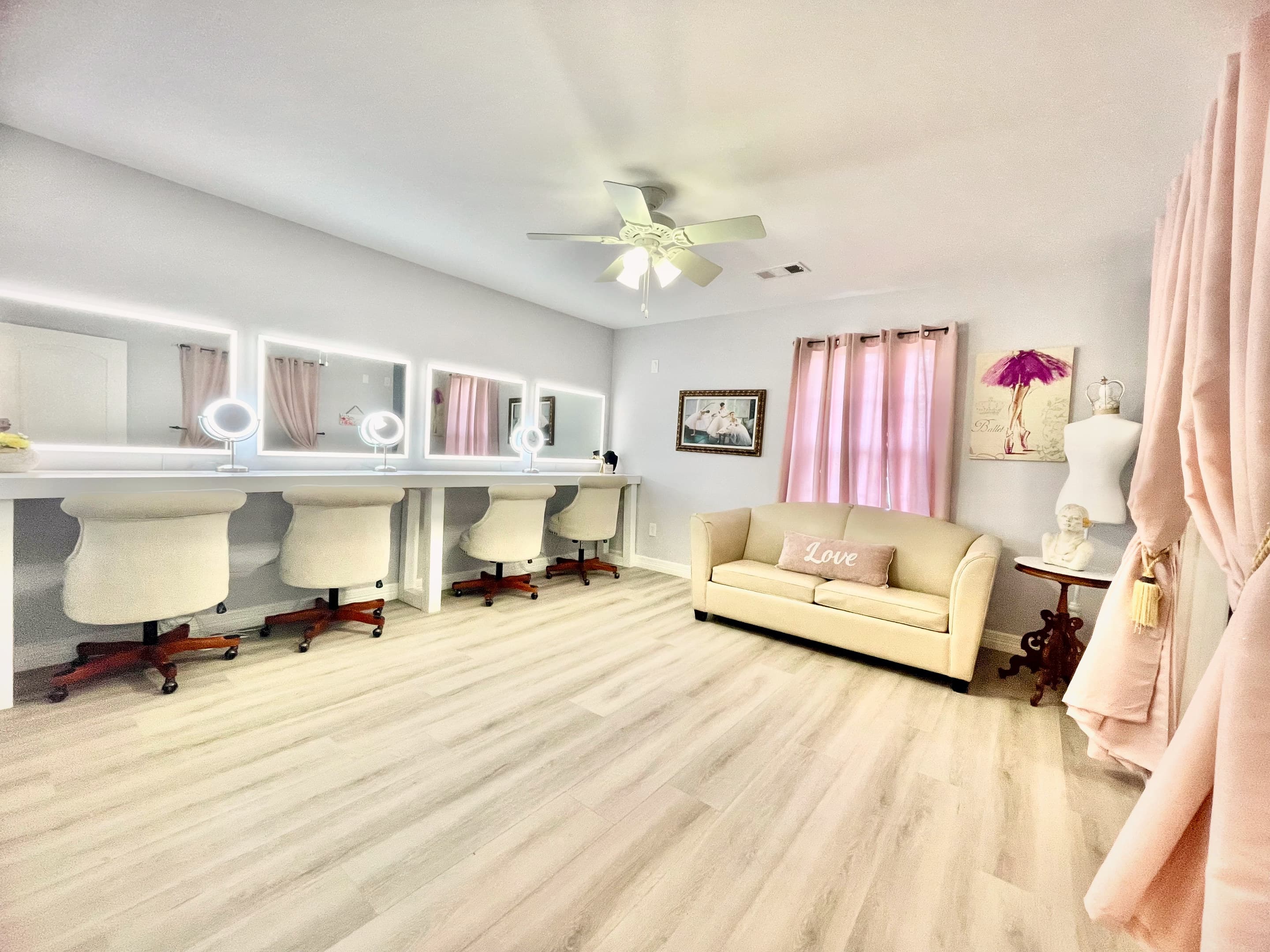 The bridal suite, with a row of lit vanity mirrors, armchairs and blush drapes